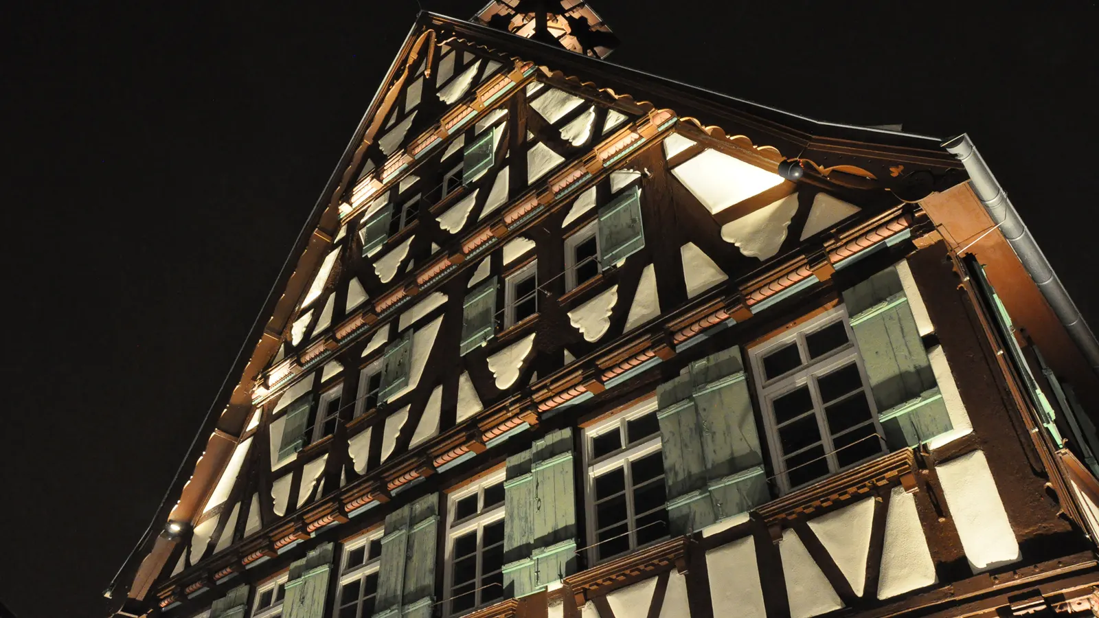 Façade à colombages d'une ancienne mairie éclairée dans la nuit noire